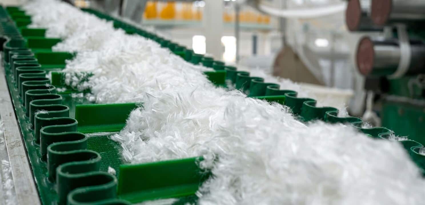 Biodegradable PLA staple fiber on production conveyor belt